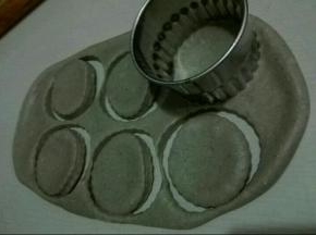 醒发好的面团，擀成大片，找出同杯子蛋糕模具大小的圆形，扣压六个圆形出来