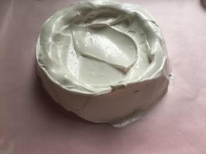 蛋白霜倒入烤盘中间位置，抹出圆形，中间凹造型