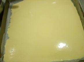 筛入玉米淀粉拌匀，倒入铺好油纸的烤盘，用刮板抹平