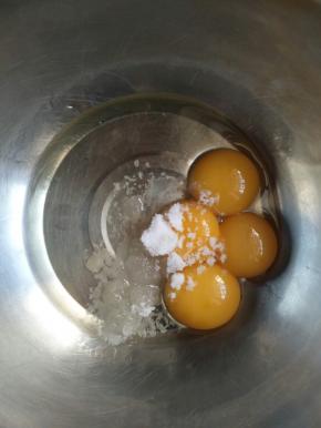 蛋黄中加入细砂糖，和玉米油，用打蛋器搅打均匀