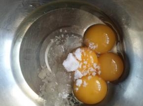 蛋黄中加入细砂糖，和玉米油，用打蛋器搅打均匀