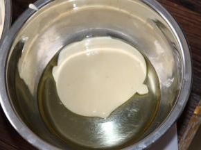 5取一小盆倒入色拉油，然后挖出少许面糊，跟色拉油混合均匀。