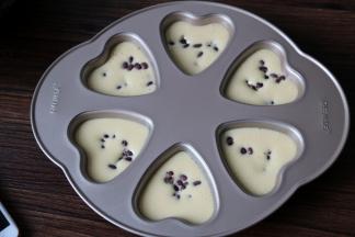 8把面糊倒入爱心模具里，九分满即可，表面撒上蜜豆。