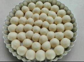 取出发酵好的面团，进行排气，均分为6克左右的小面团，搓圆，放置8寸派盘中摆好
