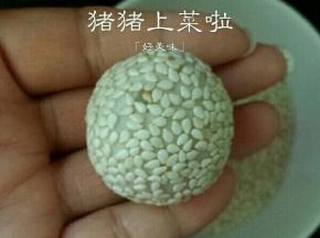 放进芝麻里滚一圈，再用手轻轻的搓一下，将芝麻按进去就可以了