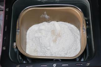 把所有原料除黄油外，先液体后固体的顺序放入面包桶里。