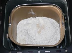 把所有原料除黄油外，先液体后固体的顺序放入面包桶里。