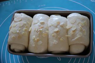 面团发酵两倍大，在表面轻轻刷一层全蛋液，撒上杏仁片。