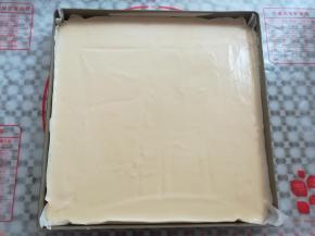 蛋糕糊倒入铺了油纸的烤盘中，轻震2下烤盘，用牙签在蛋糕糊中划几下，有助于去掉蛋糕糊中的大气泡