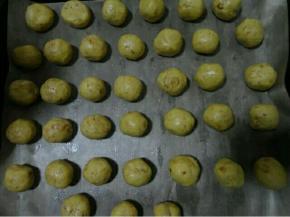 烤盘里铺油纸，我用的油布，把面团搓成一个个小圆球放进烤盘里