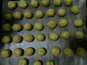烤盘里铺油纸，我用的油布，把面团搓成一个个小圆球放进烤盘里