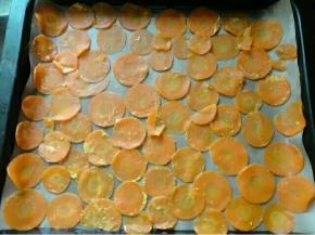 这时候烤箱预热120度，把胡萝卜片这样一片一片的摆在铺了油纸的烤盘里