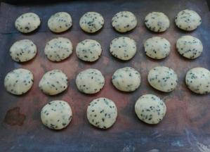 用两手手心相对按压面团，依次摆放到烤盘中，如图所示