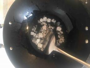 炒锅内放油，放一把冰糖，小火，用锅铲不停翻动，炒糖色。