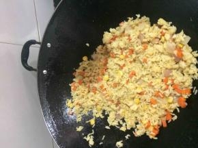 倒入玉米红萝卜洋葱粒，放盐调味，看到米饭的颜色是不是很漂亮呀