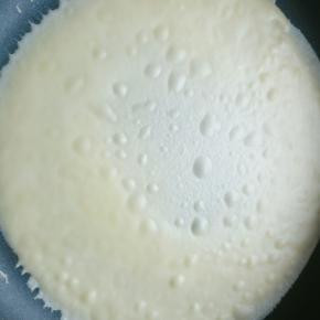 准备一块湿布铺在不粘锅边上，不粘锅开小火记得是小火，小火一定不要没有耐心，舀一勺面糊倒入不粘锅。并转动锅子，使面糊均匀沾满锅底，等面糊表面布满气泡，把锅子拿下放到旁边的湿布上，等气泡消失就可以揭下来了，很好拿，一下就下来了(如果面糊转到一半就凝固了，说明你的火候还是太大，需要再小点)