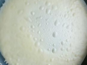 准备一块湿布铺在不粘锅边上，不粘锅开小火记得是小火，小火一定不要没有耐心，舀一勺面糊倒入不粘锅。并转动锅子，使面糊均匀沾满锅底，等面糊表面布满气泡，把锅子拿下放到旁边的湿布上，等气泡消失就可以揭下来了，很好拿，一下就下来了(如果面糊转到一半就凝固了，说明你的火候还是太大，需要再小点)