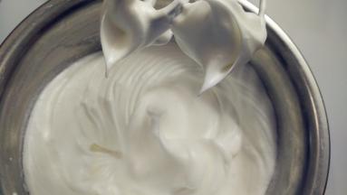 往蛋白中分3次加入糖粉，打至干性发泡。（首先，用打蛋器低速将蛋白搅打至起鱼眼泡，加入1/3的糖粉。接着，继续用电动打蛋器高速搅打，至蛋白体积膨胀1倍，再加入1/3的糖粉。然后，继续用电动打蛋器中速搅打，稍微出现纹路，加入剩余的1/3的糖粉。最后低速搅打，直至明显感到阻力，提起打蛋器时尖端是短而小的尖峰即可。）