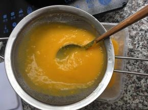 5、加入所有配料的南瓜泥倒入过滤网中过滤到容器中；我用的是塑料的长方形盒子，大家可以选择自己喜欢的形状即可。