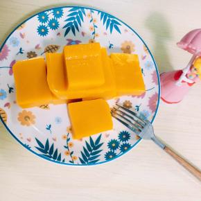 7、拿出凝固好的南瓜泥，用电吹风吹盒子四周方便脱模，倒扣在案板上，切好摆盘。