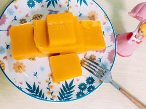 7、拿出凝固好的南瓜泥，用电吹风吹盒子四周方便脱模，倒扣在案板上，切好摆盘。