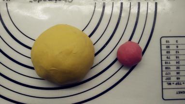 半个小时后，取出面团。因为我打算做成鸡爸爸、鸡妈妈、鸡宝宝三种大小，所以面团也分成不同大小。先将面团分出三个，分出一个105g（原色面团），一个90g（加色素做成黄色面团，其中15g做手脚嘴巴之类），一个10g（加色素做成红色面团），剩下的几克原色面团备用。