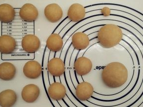 发酵好的面团用擀面杖排气，先分割出一个48g的面团（做耳朵），一个64g的面团（做手脚），以及一个5g的面团（做眉毛）。剩下的把它们均分成16份做泰迪熊的头和身体。将它们都滚圆之后盖上保鲜膜松弛15分钟。