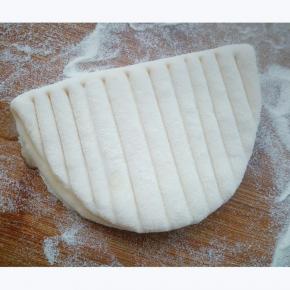 椭圆形一半抹油后，对折，用刀背外表面按压均匀的平行线