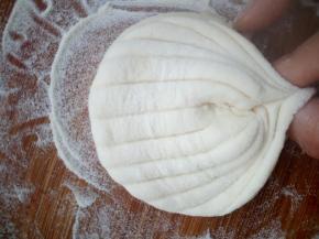 将两手指捏住中轴线的两侧向内捏合，同时将中间凸起部分向下按一下