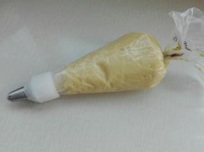 准备好裱花袋及自己喜欢的裱花嘴，将上述做好的面团放入裱花袋中