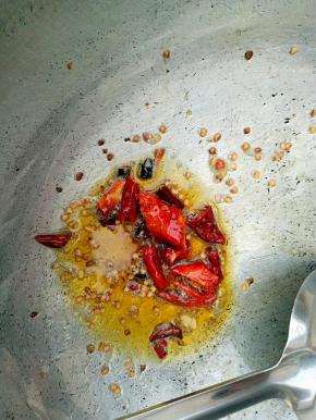 锅里放油，油稍热时放入干辣椒，待辣椒炸黄时关火