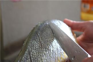 .处理好的鱼清洗干净，表面切斜刀；划刀让鱼入味，割浅一点，割深了煮的时候鱼肉会碎，深度大概为1厘米