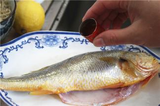 把处理干净的鱼用料酒和少许盐涂抹均匀，1斤鱼放2克-4克盐，腌制半小时