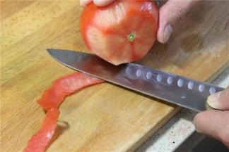 洗净的番茄去皮，番茄去皮是为了食用的时候口感更好，可以直接用刀去皮，也可以在锅内烧开水，将番茄放入锅内烫1分钟，然后捞出去过冷水揭掉表皮。用开水烫过的番茄味道比较酸，所以可以根据自己的烹饪习惯和口味选择不同去皮的方法。