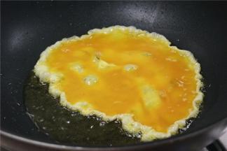 锅内到少许的油，油温烧至5成热，倒入蛋液煎至表面微黄