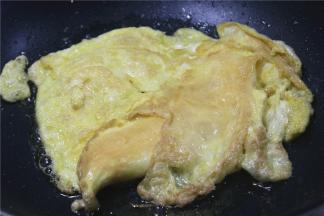 要想鸡蛋体积蓬松，首先要将鸡蛋充分的打散，然后在蛋液中加少许的料酒或者温水，加料酒可以去腥气，加温水可以在高温中炒至的时候行程水蒸气，使蛋液会气泡，让鸡蛋快速的蓬松。其次就是油温高的时候下鸡蛋，冷油炒出来的鸡蛋容易干瘪