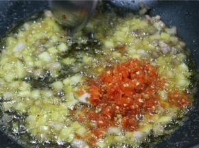 锅中下入少许豆瓣酱、红泡椒碎，混合炒香
