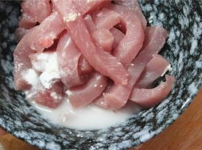 切好的里脊肉放入碗中，加入半勺糖，盐和鸡精，小半勺料酒，加少许的玉米淀粉，抓拌均匀之后腌15分钟入味。