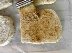 剪一张和烤箱晾架一样的油纸铺在晾架上，用毛刷在每一片馒头片切面上刷一层混合好的调料植物油，刷好后全部放在油纸上