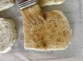 剪一张和烤箱晾架一样的油纸铺在晾架上，用毛刷在每一片馒头片切面上刷一层混合好的调料植物油，刷好后全部放在油纸上