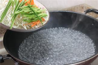 准备一锅开水，放入上面几步准备绿豆芽、黄瓜丝和胡萝卜丝，汆水的时间不要太长，要不不够脆 。