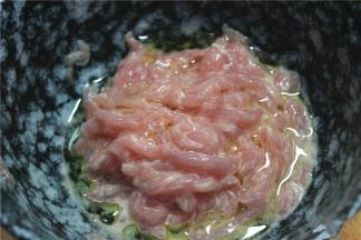 干净的猪肉切成丝，放入碗内，加嫩肉粉，鸡蛋清和水搅拌均匀。