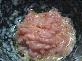 干净的猪肉切成丝，放入碗内，加嫩肉粉，鸡蛋清和水搅拌均匀。