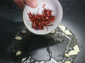 锅内留底油，放入葱姜和干辣椒丝炒香，放入滑好油的笋丝肉丝翻炒均匀