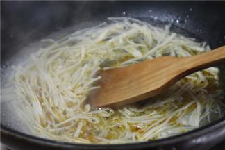 金针菇去根洗净，放入锅内焯水备用。焯水时可加入少许盐和香油，可以让金针菇更鲜亮