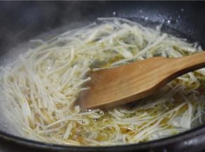 金针菇去根洗净，放入锅内焯水备用。焯水时可加入少许盐和香油，可以让金针菇更鲜亮