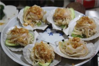 将贝壳放入盘中，依次放上丝瓜，金针菇和扇贝，淋入适量金蒜