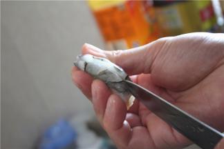用到刀轻轻的从虾背处切开，注意不要切的太深，以免切断