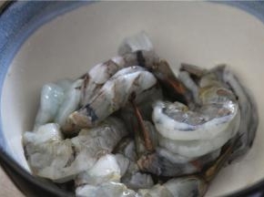 把准备好的虾调味，倒入半勺料酒去腥，少许的盐，鸡精和胡椒粉，抓拌均匀，腌10分钟左右
