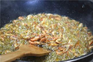 倒入河虾快速炸香，但不要炸太干。炸虾的时候油温一定要烧足够热，油温不够会把油吸进虾里，油温够就不会出现这样的问题。另外，如果炸的虾用量比较多，也可以分批次油炸，以免全部下锅受热不均油炸不好。